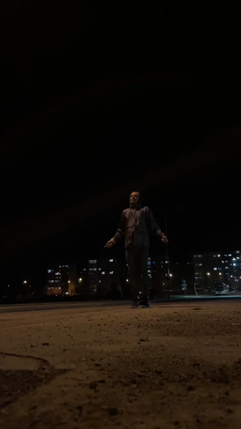 Nighttime athlete prepares with dynamic moves on rough asphalt surface Stockbeeldmateriaal 347334119