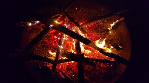 A nighttime campfire in super slow motion. Flames and embers burn slowly in.. Video stock 296756632