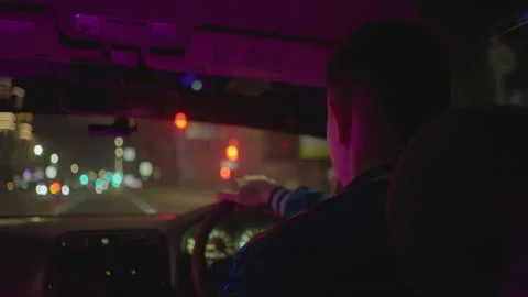 Nighttime city drive, Driver reflects after long day, City street illuminated Stock Footage 330957227