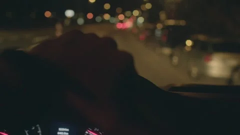 Nighttime city drive, Man cautiously drives through city streets at night Stock Footage 324591547