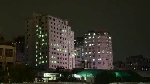 Nighttime cityscape with illuminated windows in tall buildings against a da.. Stock Footage 340056053