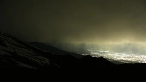 Nighttime cityscape view from mountain peak, illuminated skyline under clouds 스톡 동영상 340392694