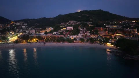 Nighttime coastal view of beach and illuminated buildings along shoreline Stock Footage 336926733