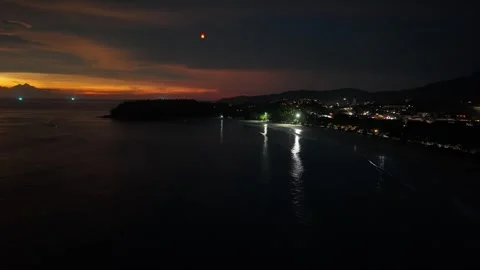 Nighttime coastal view with glowing lanterns illuminating the ocean horizon Vídeo Stock 342332907