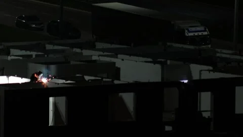 Nighttime construction work with welders creating sparks, illuminated by light Stock Footage 344864678