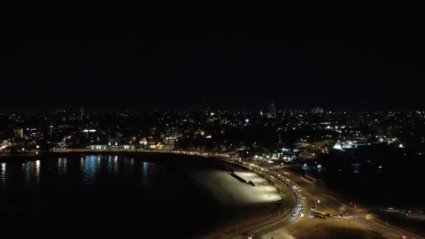Nighttime drone ascent capturing Montevideo coastal lights Stock Footage 309565243