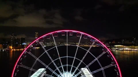 Nighttime Drone Shot of Hong Kong Through Ferris Wheel, Skyline, and Bridge Stock Footage 279457053