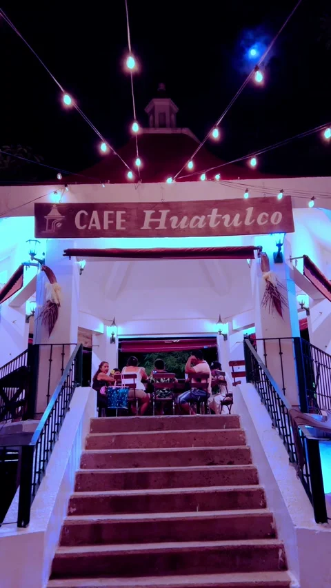 Nighttime exterior of Cafe Huatulco with string lights and illuminated entrance Stock Footage 343926706