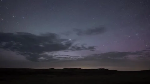 Nighttime lapse of a star filled sky with clouds moving Stock Footage 242367907