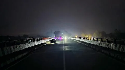 Nighttime long exposure of car light trails on wet highway bridge wet road Fotos Stock