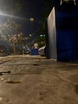 Nighttime low angle view of textured stone pavement in a city park with boke Stock Photos