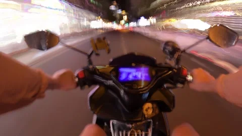 Nighttime motorcycle ride through busy city streets showcasing vibrant lights Stock Footage 297930801