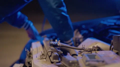 Nighttime roadside engine assessment with focus on cables and battery terminals Stock Footage 330955433