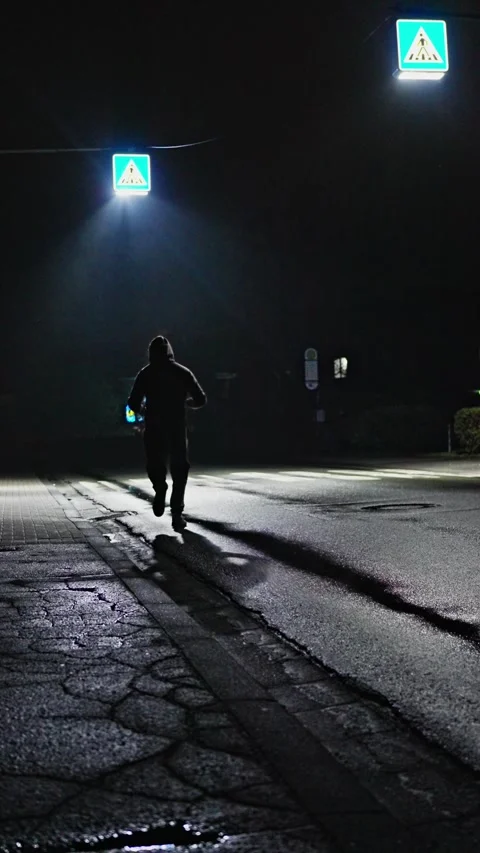 Nighttime Runner in Urban Streets Under Illuminating Streetlights All Around Him Stock Footage 315518391