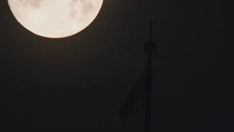 A nighttime scene features a full moon brightly lit, with a silhouette of an Video stock 277074449