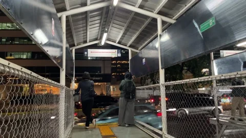 Nighttime scene at a temporary bus stop in an urban city. Видео 333809350