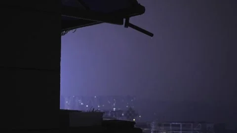 Nighttime thunderstorm with heavy rain falling over a dark urban apartment Stock Footage 342099331