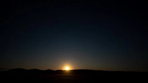 Nighttime timelapse of a bright full moon rising above rolling hills. Stock Footage 278682631