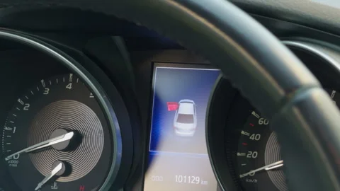 Nighttime vehicle dashboard featuring parking sensor alert and instrument 스톡 동영상 335685475