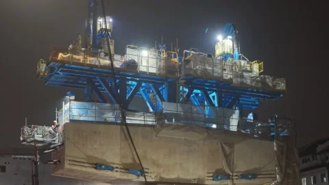 A nighttime view of an active building construction zone with illuminated Stock Footage 347036928