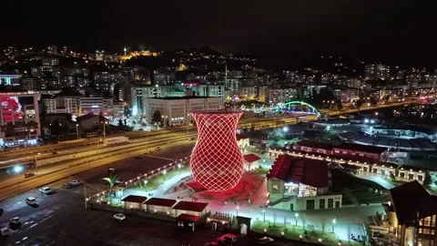 Nighttime view of a city with a red tower and a bridge Vídeo Stock 268905414