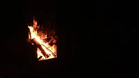 A nighttime view of a crackling campfire with sparks flying into the air.  Stock Footage 276283178