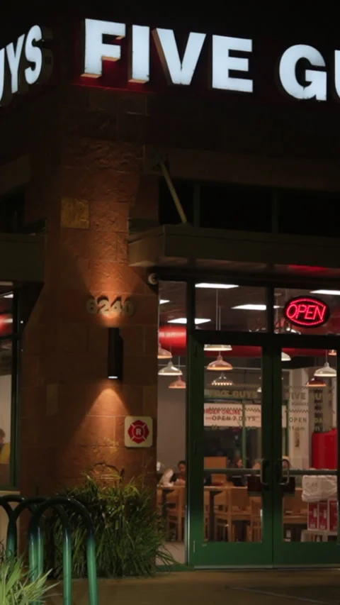 Nighttime View of Five Guys Restaurant in Vertical Format Stock Footage 320039490