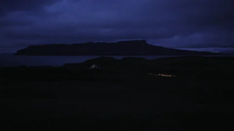 Nighttime view of mountain landscape by the ocean with cloudy skies Stock Footage 325931841