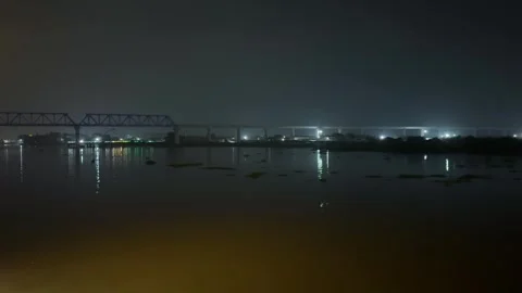 Nighttime view of a tranquil river with illuminated bridges reflecting on t.. Vidéo 340056082