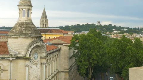NîmeFrance Rooftops with Clock, tree tops castle in distance partial road Stock Footage 101187921