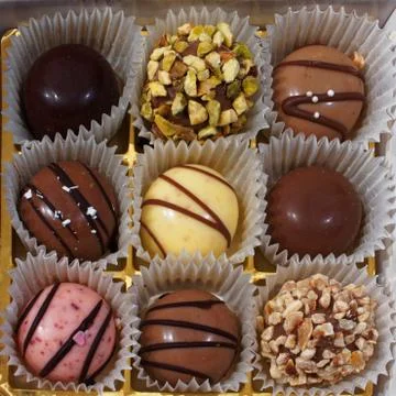Nine delicious colored chocolates inside a box. 库存照片
