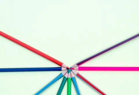 Nine different colored pencil crayons arranged in circled shape while pointin Stock Photos