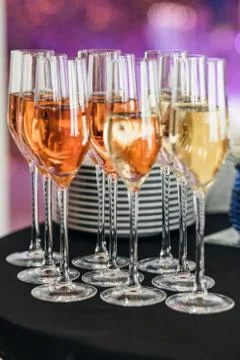 Nine glasses of champagne on the table. stack of plates in the background 스톡 사진