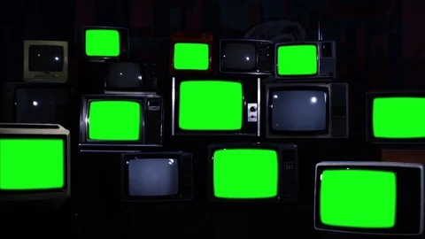 Nine Old TV Sets Turning On Green Screen and Stacks of Retro TVs. Zoom In Slow. Stock Footage 90736684