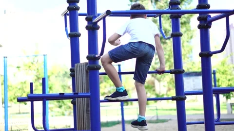 Nine-year-old boy climbs stairs outdoors in the park Stock Footage 248714718