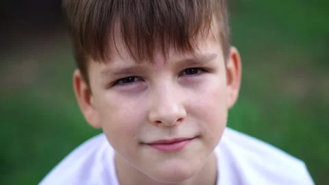 A nine-year-old boy sits quietly on the street. close-up portrait. Stock-Footage 248714625
