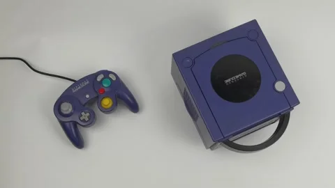 Nintendo Gamecube purple console rotating next to purple joypad Stock Footage 231706014