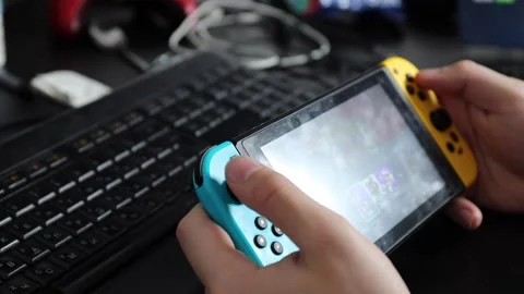 Nintendo switch grip controller is held in the hands of a guy. B Stock Footage 219565137
