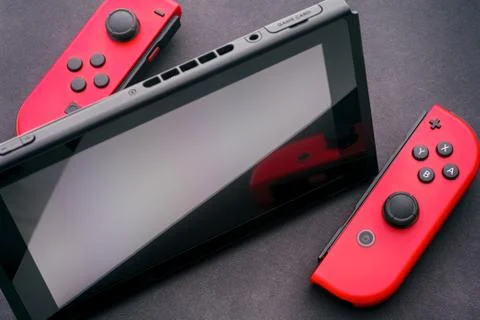 Nintendo Switch video game console with two Joy-Cons. Black background. Stock Photos