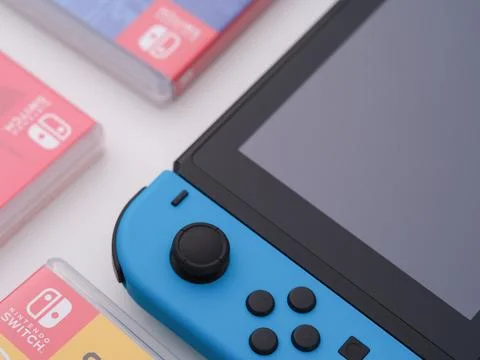 A Nintendo Switch video game console with a blue joy-con Stock Photos