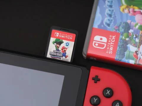 A Nintendo Switch video game console with a Super Mario Bros. Wonder game card Stock Photos