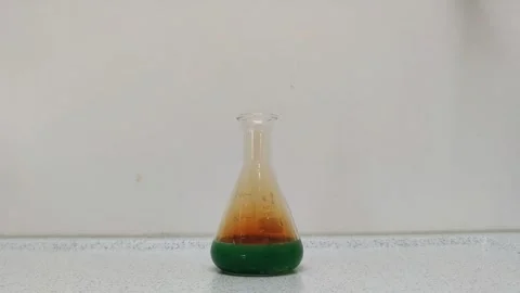 Nitric acid is placed in an Erlenmeyer flask with copper shavings Stock Footage 267068268