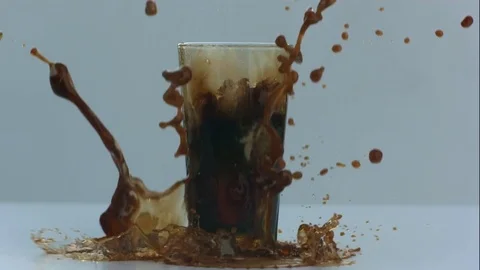 Nitro Cold Brew Coffee Splashes Over Cup and Onto White Table in Slow Motion Stock Footage 75107999
