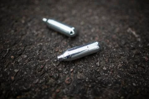 Nitrous Oxide Canisters on ground Stock Photos