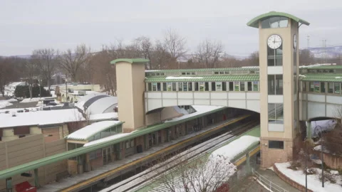 NJT Commuter train pulling into Ramsey Route 17 train station on  a winter day. Stock Footage 148437920