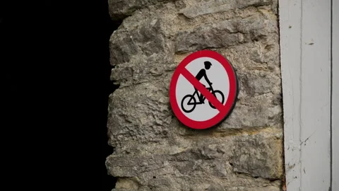 No Bicycles Allowed Sign Displayed Prominently on a Solid Stone Wall for Public Stock Footage 293677679