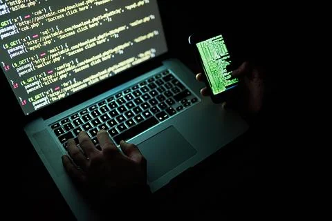 No code is uncrackable. an unidentifiable hacker using a laptop late at night. 스톡 사진