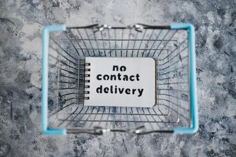 No Contact Delivery text on notepad inside shopping basket symbol of purchase Stock Photos