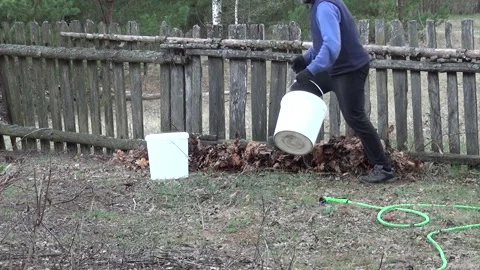 No-dig garden bed preparation. Man pouring compost from autumn leaves onto .. Video stock 343717556