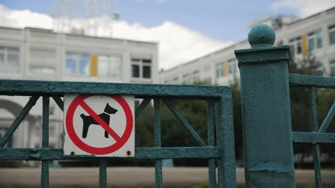 No dog red ring warning street sign on metal fence, public school property 스톡 동영상 210824809